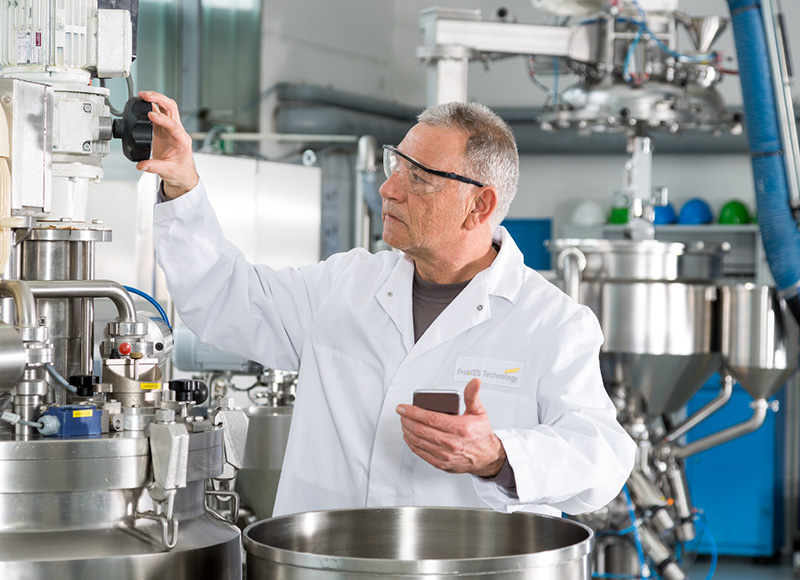 Technician operating industrial mayonnaise processing equipment in a production plant