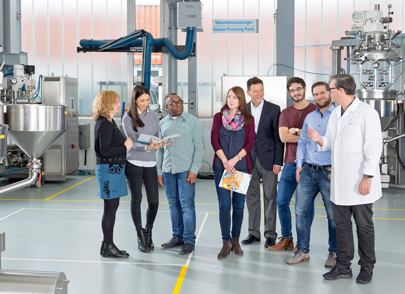 Group of professionals discussing industrial food processing systems in a factory