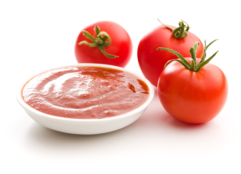 Tomato ketchup with fresh tomatoes as an example of industrial sauce production
